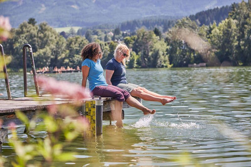 Freundinnen kühlen ihre Füße im Lanser See